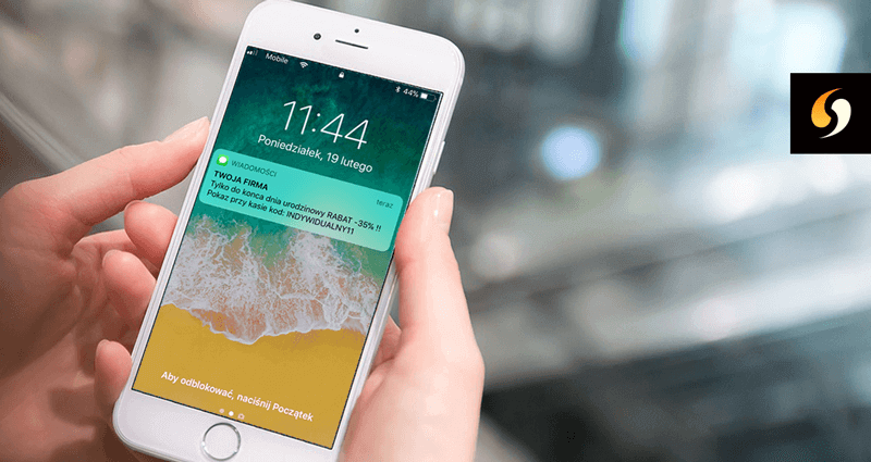 Ekran smartfona z wyświetloną wiadomością SMS z nadpisem Twoja Firma